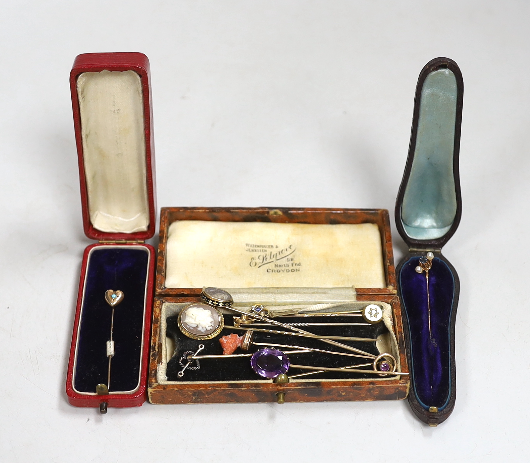 A Victorian yellow metal and black enamel stick pin, with hair beneath a glazed panel, 77mm and nine other assorted yellow metal and gem set stick pins including two 9ct, one 585 and one 15ct.
